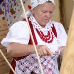 Kobieta w stroju ludowym podczas gotowania.