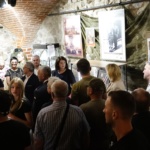 Turyści w galerii oglądający wystawę.