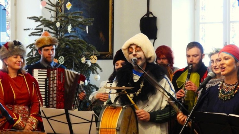 Muzycy śpiewający i grający na instrumentach.