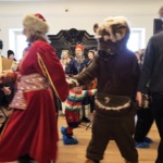 Tańczący ludzie w kolorowych strojach karnawałowych.